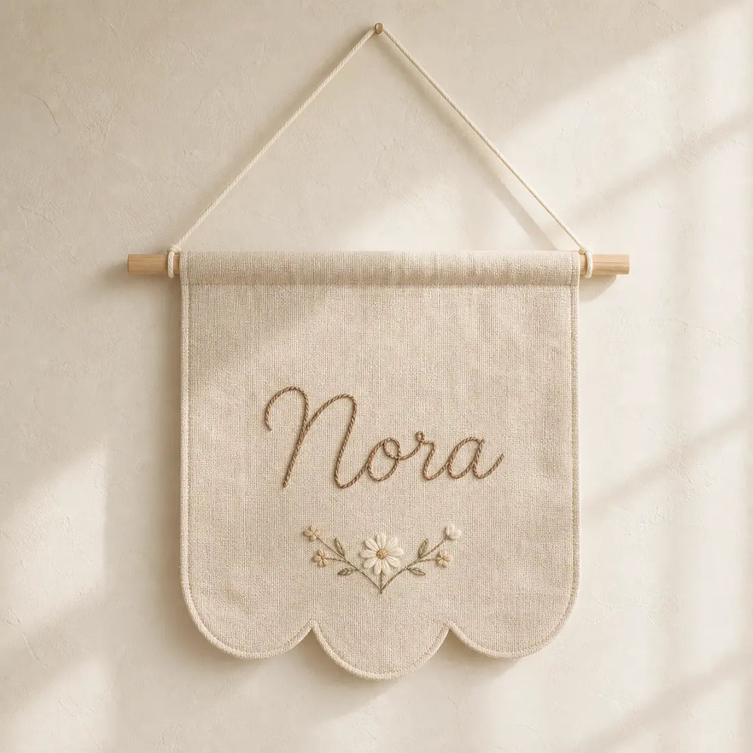 Personalized fabric name banner on a warm ivory background